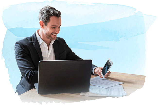 Man in suit using laptop and cell phone